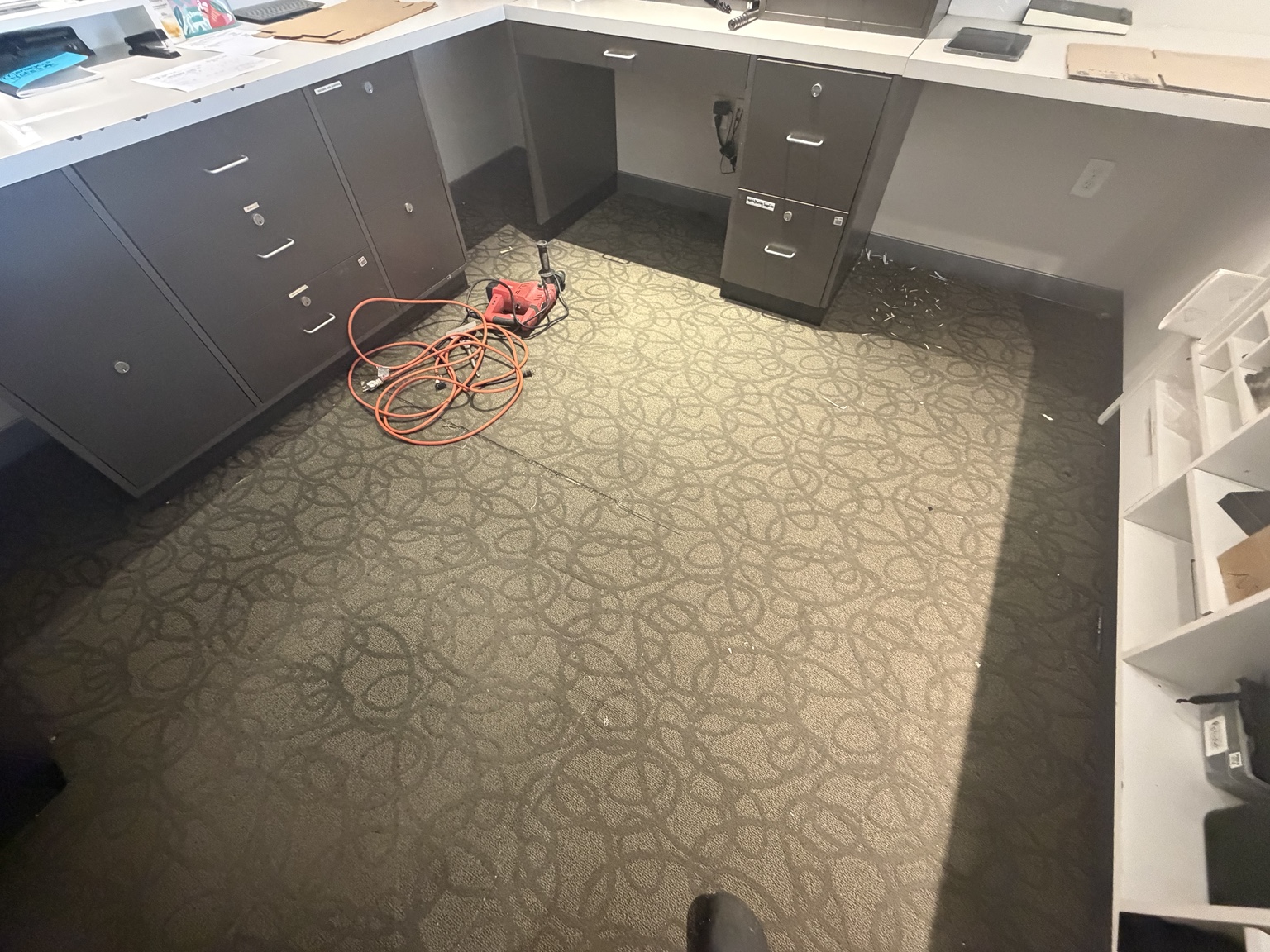 KAY Jewelers work area with patterned carpet before flooring replacement