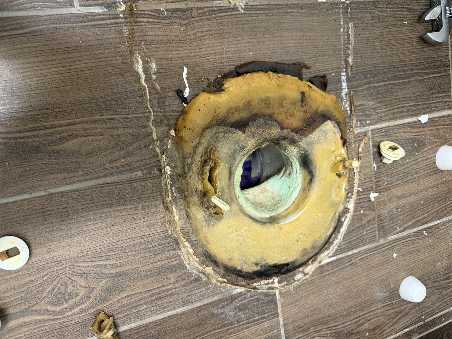 Exposed toilet flange with old wax seal before repair at Mattress Firm